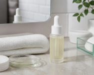 Glass dropper bottle with pale yellow liquid on a bathroom counter