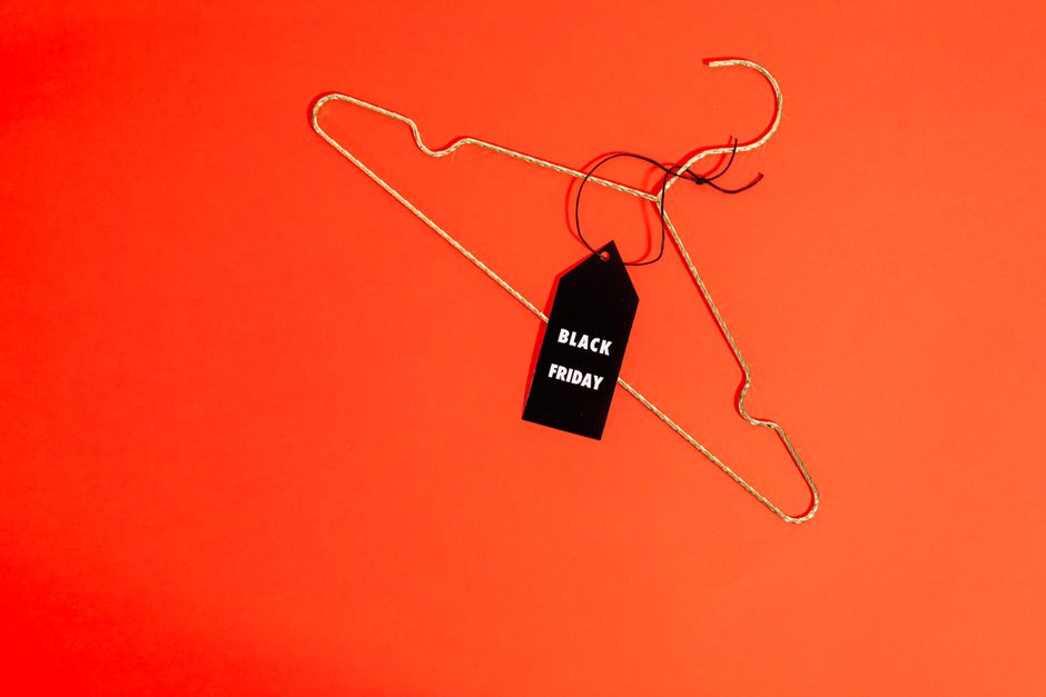 Gold wire hanger with Black Friday tag on red background. Perfect for sale promotions.