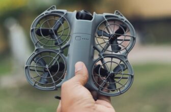 A compact controller-free drone held in one hand, similar to the DJI Neo