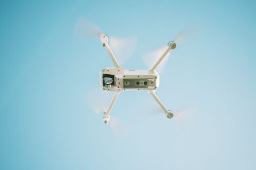 A drone flying against a clear blue sky over the UK