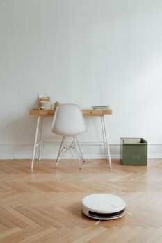 White robot vacuum cleaner on a hard floor in a living room