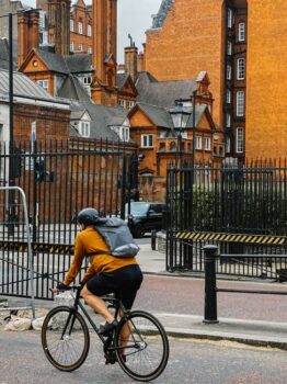 Cyclist riding past historic buildings in London, UK
