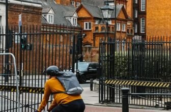 Cyclist riding past historic buildings in London, UK