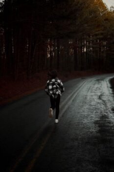 Runner on a wet forest road in activewear