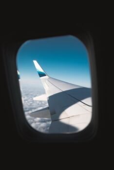 Airplane window seat view used to illustrate flight price tracking